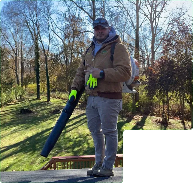 Jerson of JBH Landscaping clearing a deck with a backpack blower in Dayton, Ohio