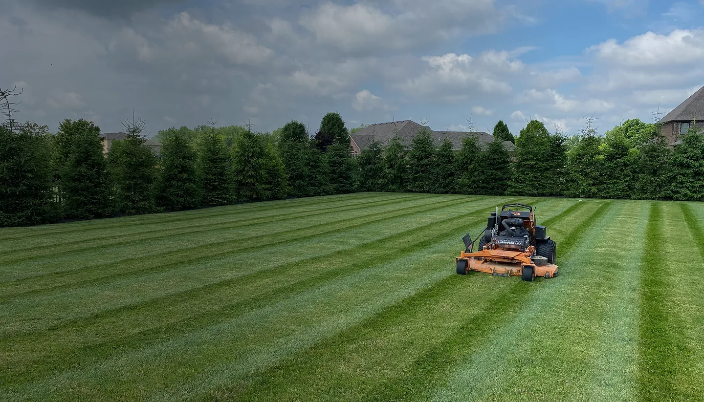 A JBH Landscaping mower cutting stripes into a large Dayton, Ohio lawn