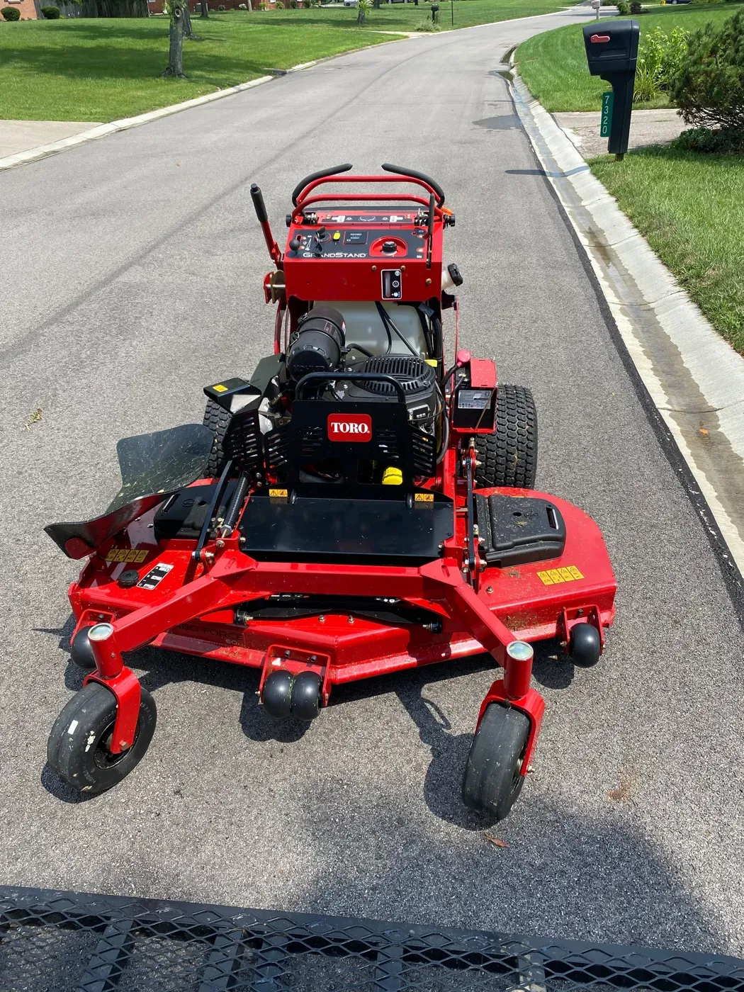 A red commercial mower on a Dayton street, ready to cut