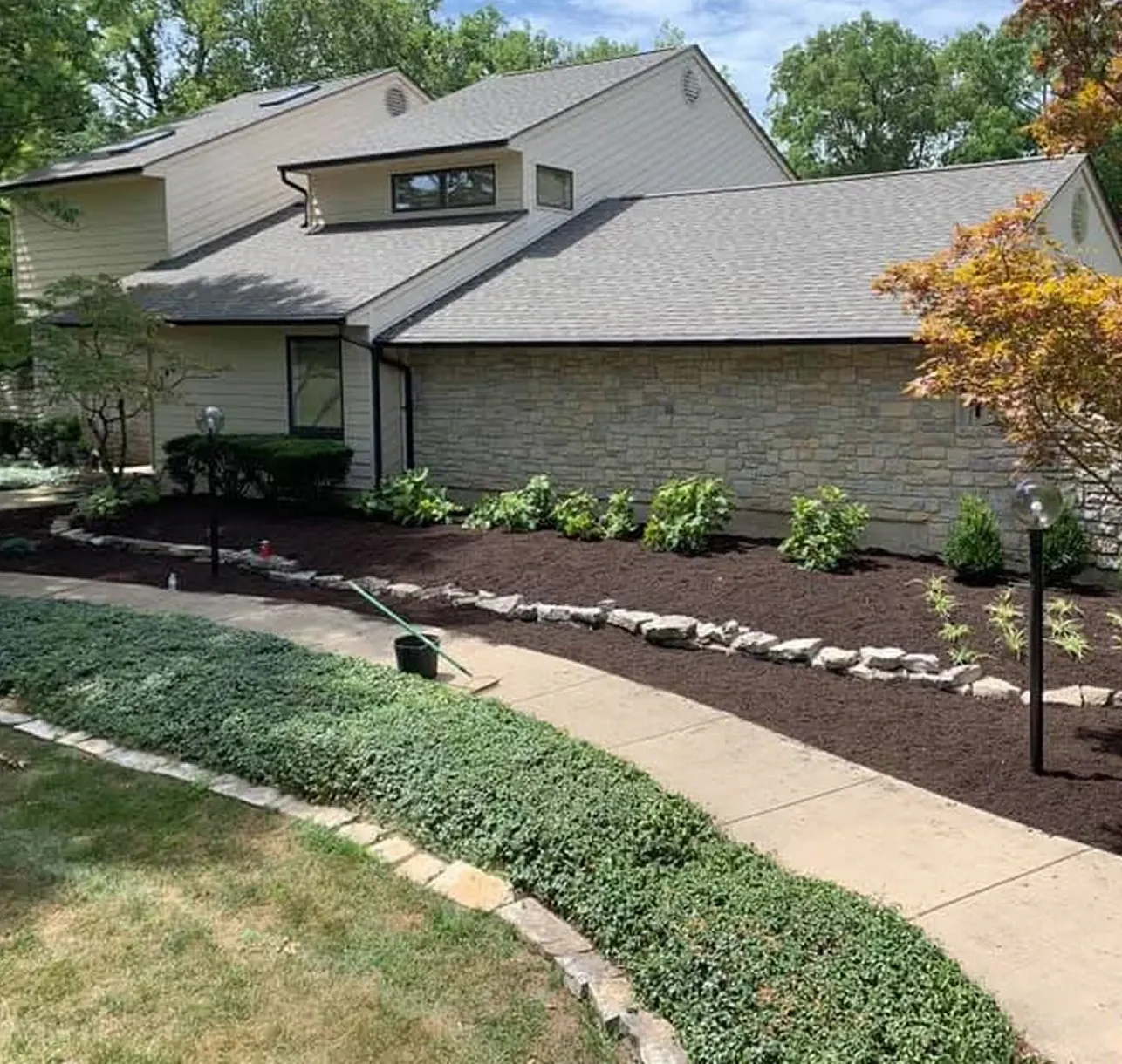 Fresh mulch bed with stone border installed by JBH Landscaping in Dayton, Ohio